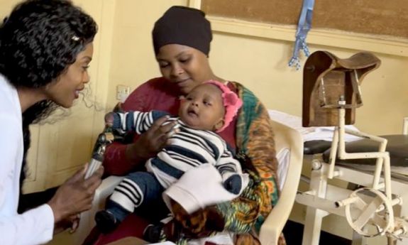 nursing student in Tanzania with mother and young child