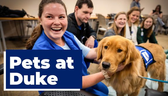 Duke Health employee enjoys time with Jerry, a dog on the Pets at Duke team.