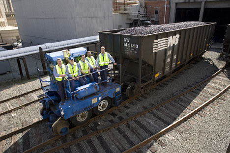FMD employees pose in front of the last rail car to bring coal to the West Campus steam plant. 