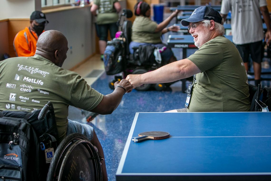 Johnny Holland, left, fist bumps Bryan McCrickerd after their game of table tennis during Valor Games Southeast in Cameron’s Hall of Honor.