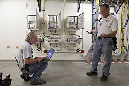 Sam Wickline, left, and Scott Hudson, IT analysts with Duke's Office of Information Technology, check cellular activity at the Duke Medicine Pavilion during work in late 2013.