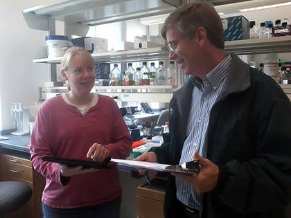 Randy Smith, departmental manager in the Department of Biology, and Debra Murray, a research scientist in the department, work through a checklist of items involved in Green Lab Certification. The pair have been taking part in the “Battle of the School