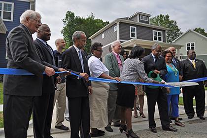 Durham Mayor Bill Bell (with the scissors), along with other local and state politicians, Phail Wynn Jr. of Duke's Office of Durham and Regional Affairs, and new Southside resident and Duke employee David Steinbrenner, attended the ribbon cutting in fron
