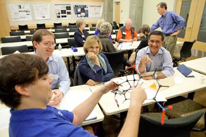 During one morning session, Duke chemistry Professor Steve Craig (in back in blue shirt) showed visitors how students can use a hands-on approach in science education.  Photo by Les Todd/Duke University Photography.