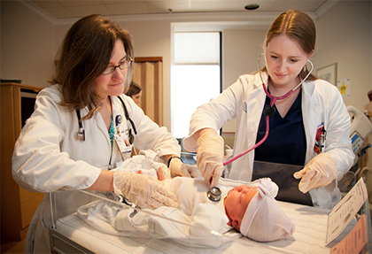 Jared Lazarus, a photographer with Duke Photography, submitted this image of Duke pediatrician Sarah Germana, MD, left, and Lauren McGill, MD, first-year pediatric resident, examining the first baby born at Duke Hospital in 2015. It was featured on the D