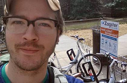 Graduate student Gabriel Yapuncich poses for a selfie by a rack of bikes with Duke's bike-share program, Zagster, as part of a social media activity for the Unpark Yourself Challenge. Yapuncich is among several employees and graduate students fighting fo