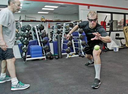 Carolina Hurricanes trainer Peter Friesen (left) watches as goalie Justin Peters performs a drill with a tennis ball while wearing stroboscopic training eyewear. Photo courtesy of Peter Friesen, @NHLCanes