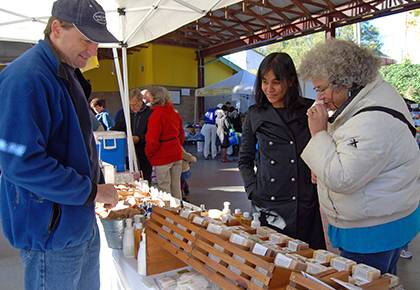 Judy Moore, right, and Vishwa Nellore at the MoonDance Soaps booth at the Durham Farmers Market. Photo by Marsha A. Green.
