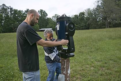 From left to right, Duke Physics lab manager Yuriy Bomze and physics professor Ronen Plesser adjust a Meade LX200GPS Schmidt-Cassegrain telescope. Photo by Duke Photography
