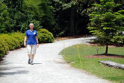 Sarah Woodring walks along a trail at Sarah P. Duke Gardens. She enjoys getting exercise by walking or jogging for 30 minutes at the gardens during workdays. Photo by Bryan Roth.