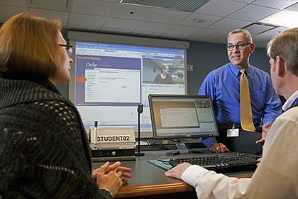 Randy Taylor, an instructional designer and trainer, leads a session on WebEx Meeting for Duke participants Lisa Cunningham Roberts, left, and Jerry Kirchner, right. Photo by Duke University Photography.