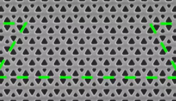 The central part of the new photonic crystal topological insulator waveguide, with the path of a photon’s path highlighted in green. The experiment showed that each turn resulted in backscattering losses of only a few percent.