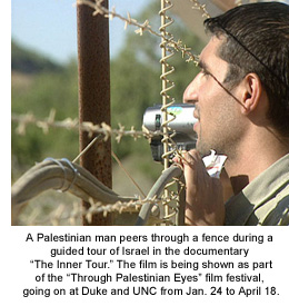 A Palestinian man peers through a fence during a guided tour of Israel in the documentary The Inner Tour. The film is being shown as part of the Through Palestinian Eyes film festival, going on at Duke and UNC from Jan. 24 to April 18.