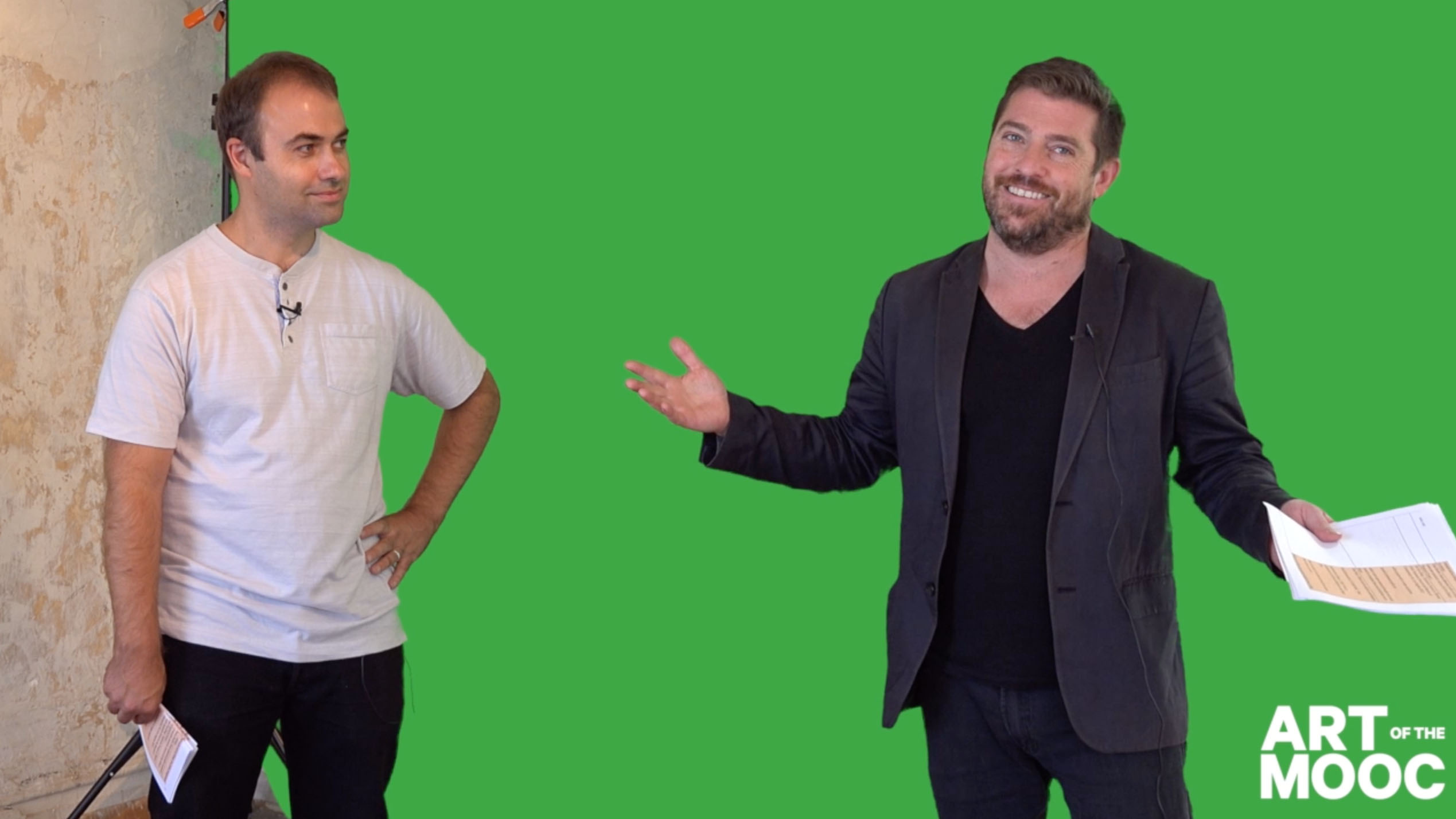 Pedro Lasch and Nato Thompson record a lecture in front of a green screen.