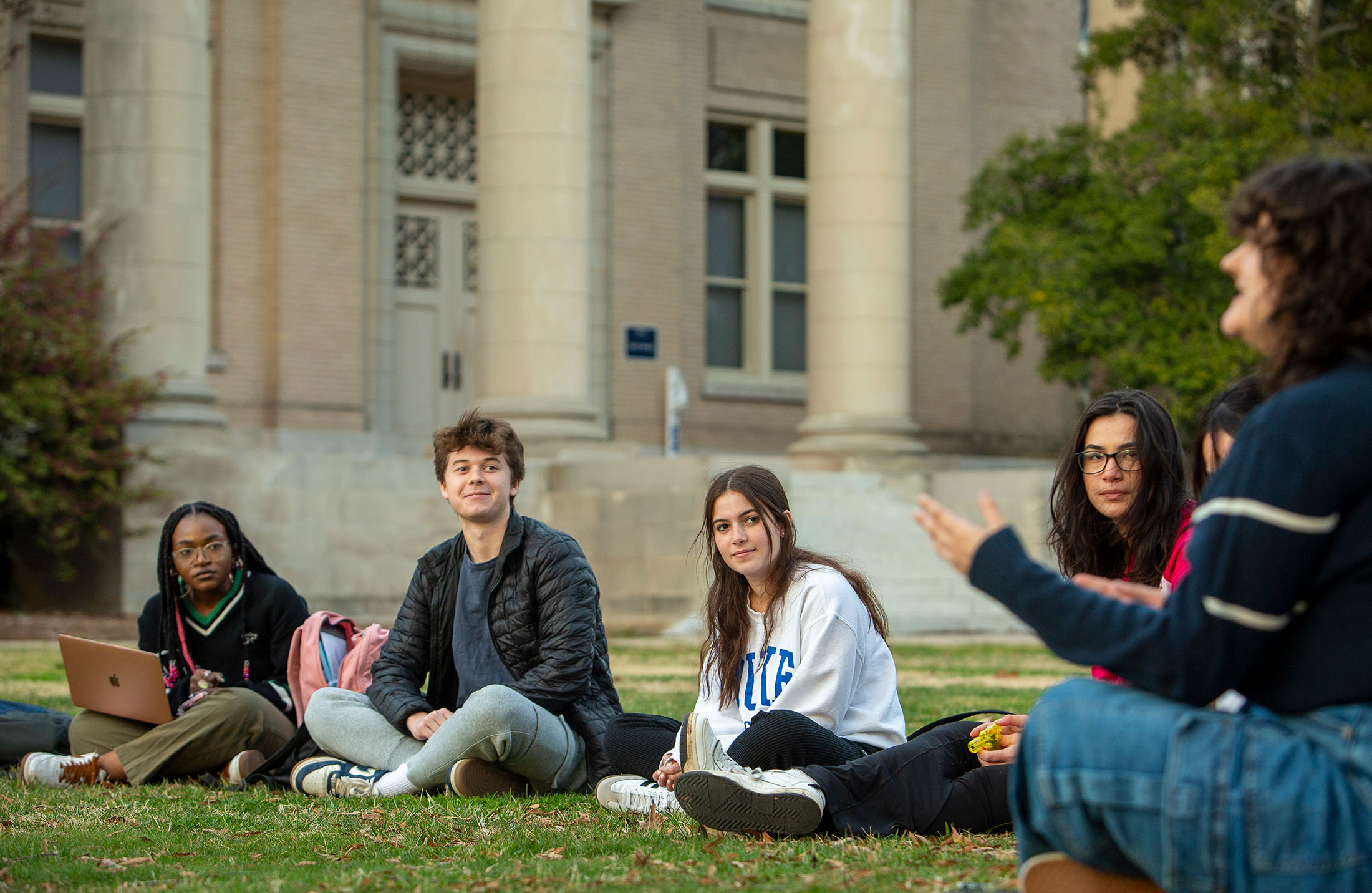 Students listen to their instructor outside on East Campus.