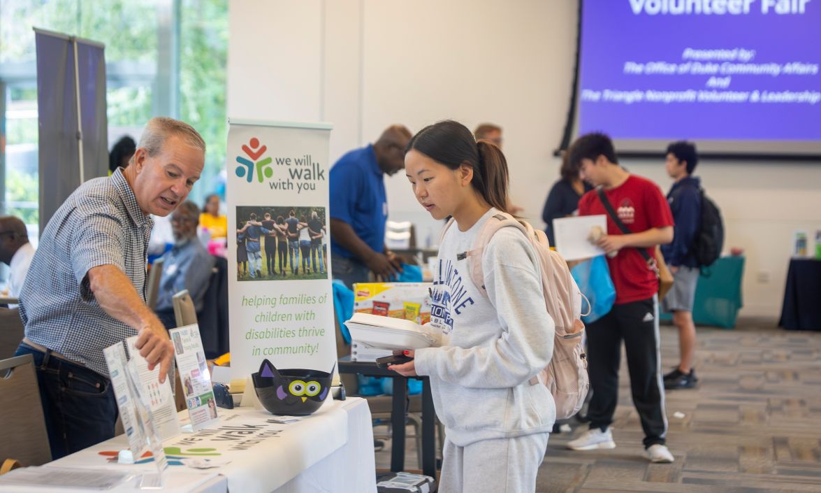 Senior Irene Feng, right, talks with Fred Hathaway Jr. of We Will Walk With You, which helps families of children with disabilities.