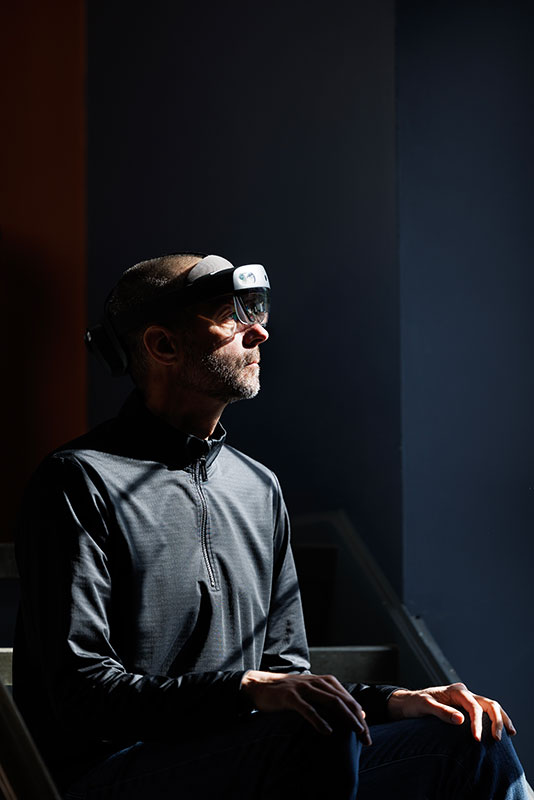 Professor Cameron McIntyre sitting in the dark with a device on his forehead