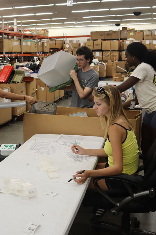 Students sorting items in a warehouse during experiential orientation