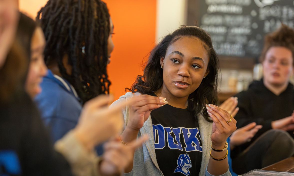 Duke student signing the word more, making gestures with her hands.