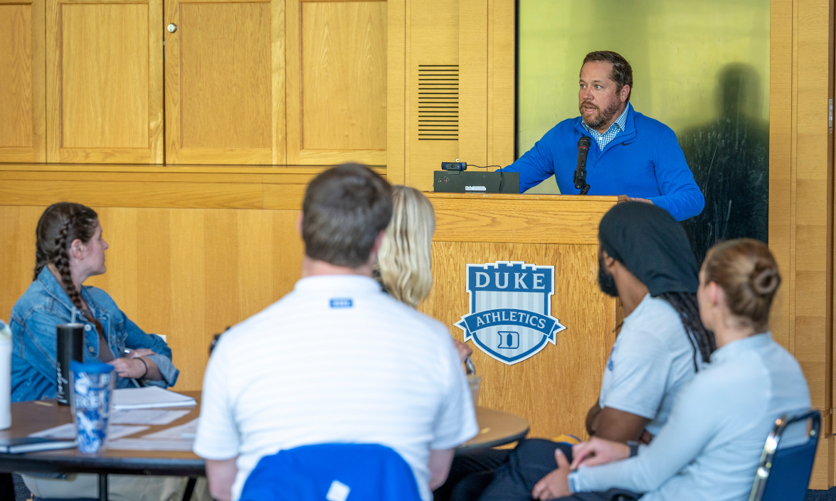 A man standing at a podium is speaking to an audience.