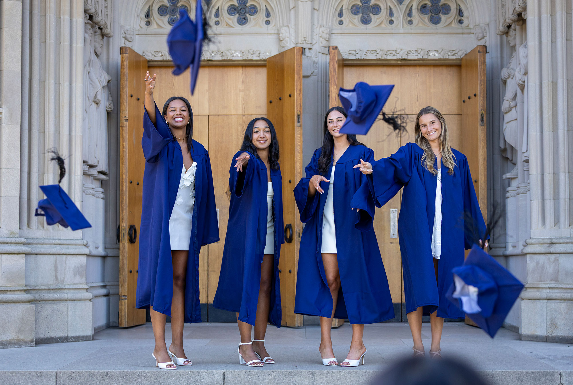 tossing the caps toward the camera in front of Chapel