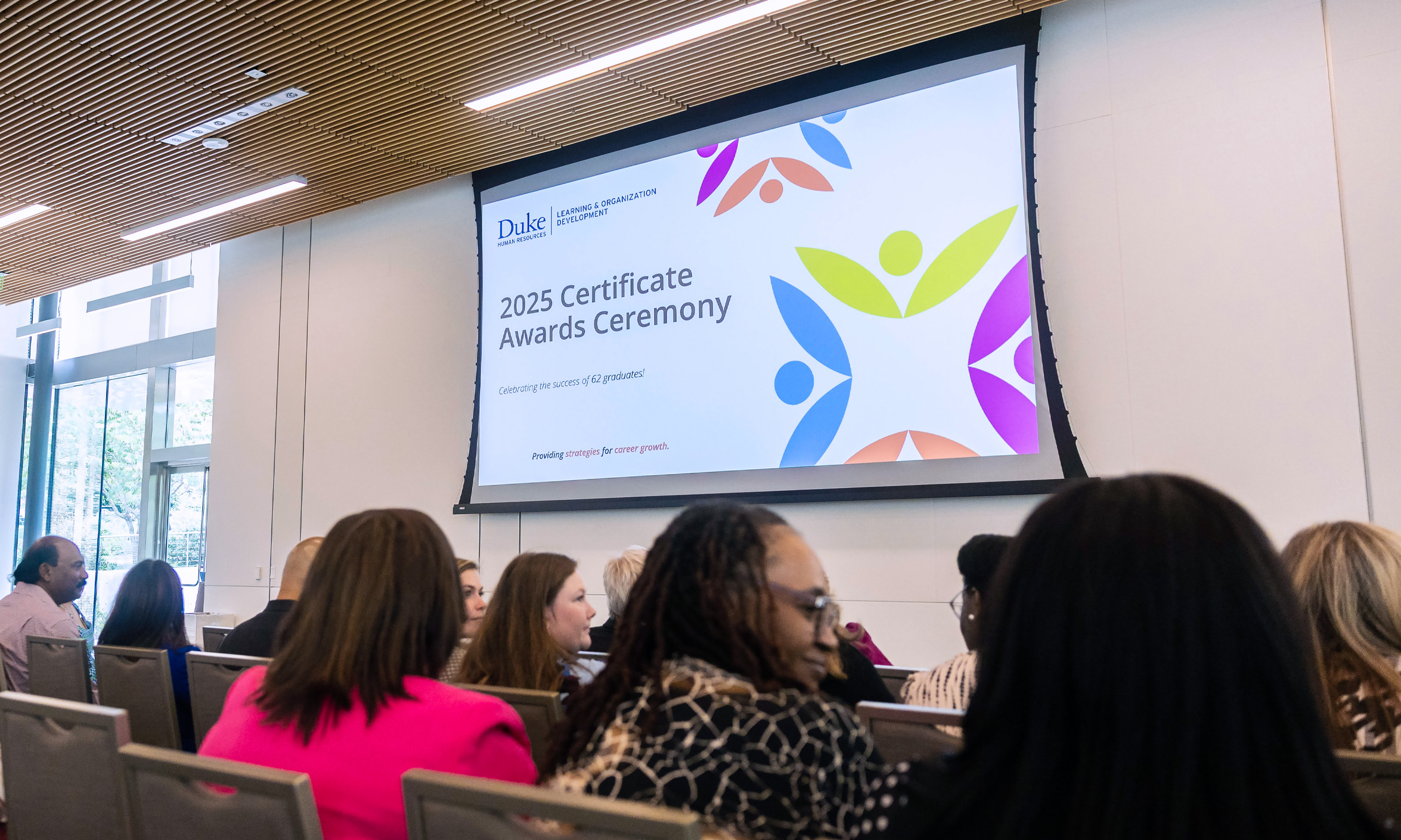 An audience sits in front of a projection screen that reads 2025 Certificate Awards Ceremony.