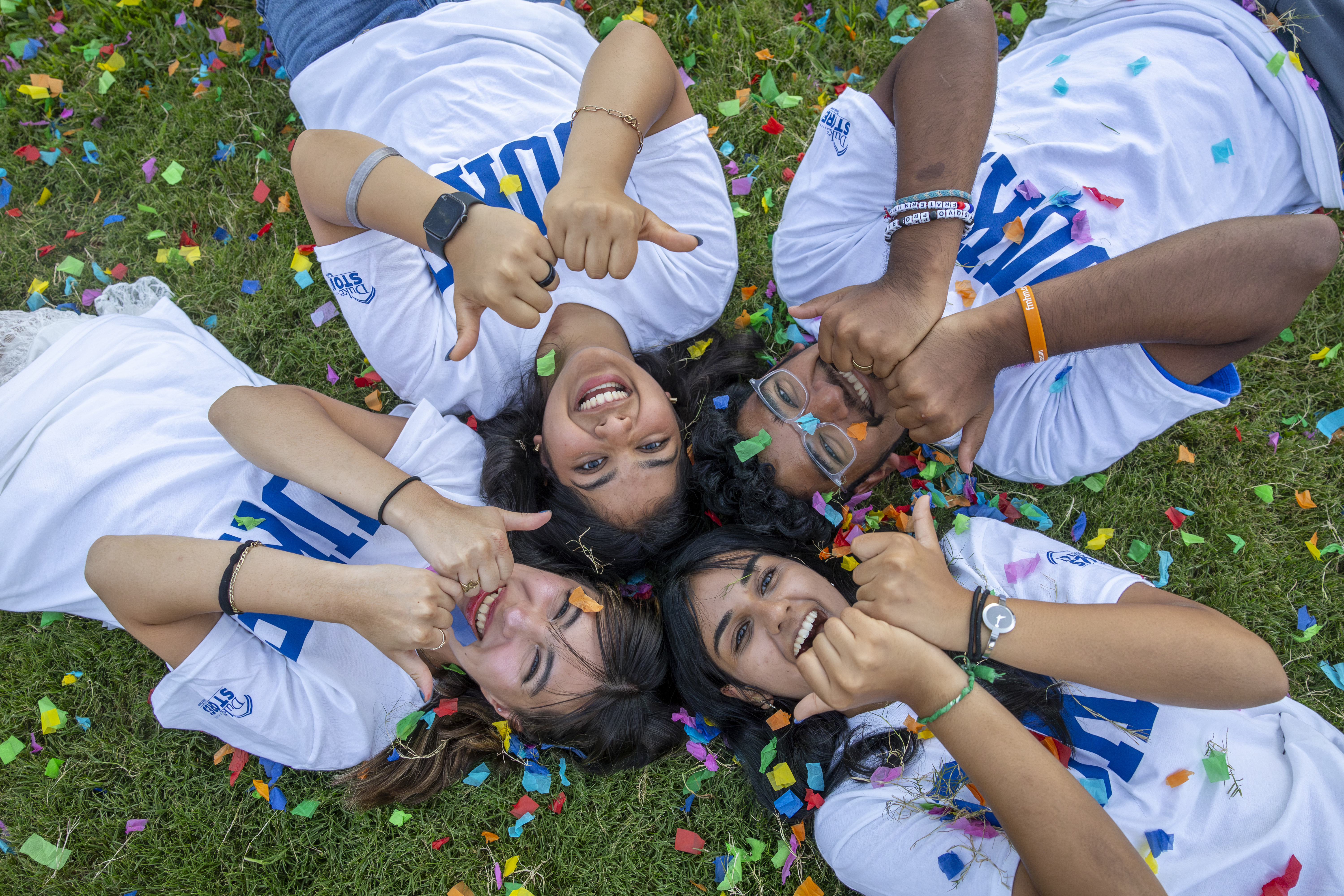 people lying on the ground giving a devil sign