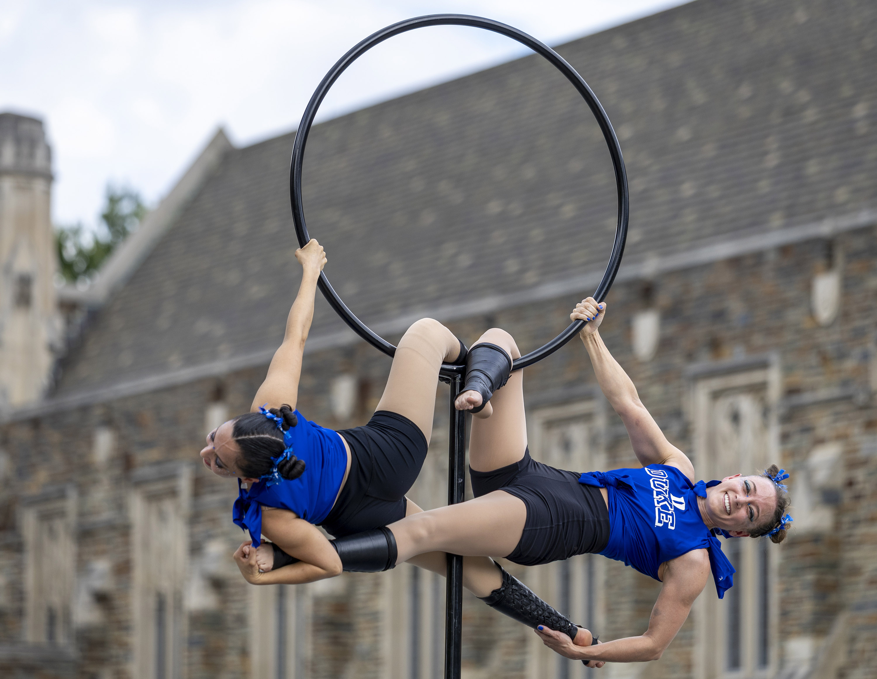 two acrobats intertwined on a hoop