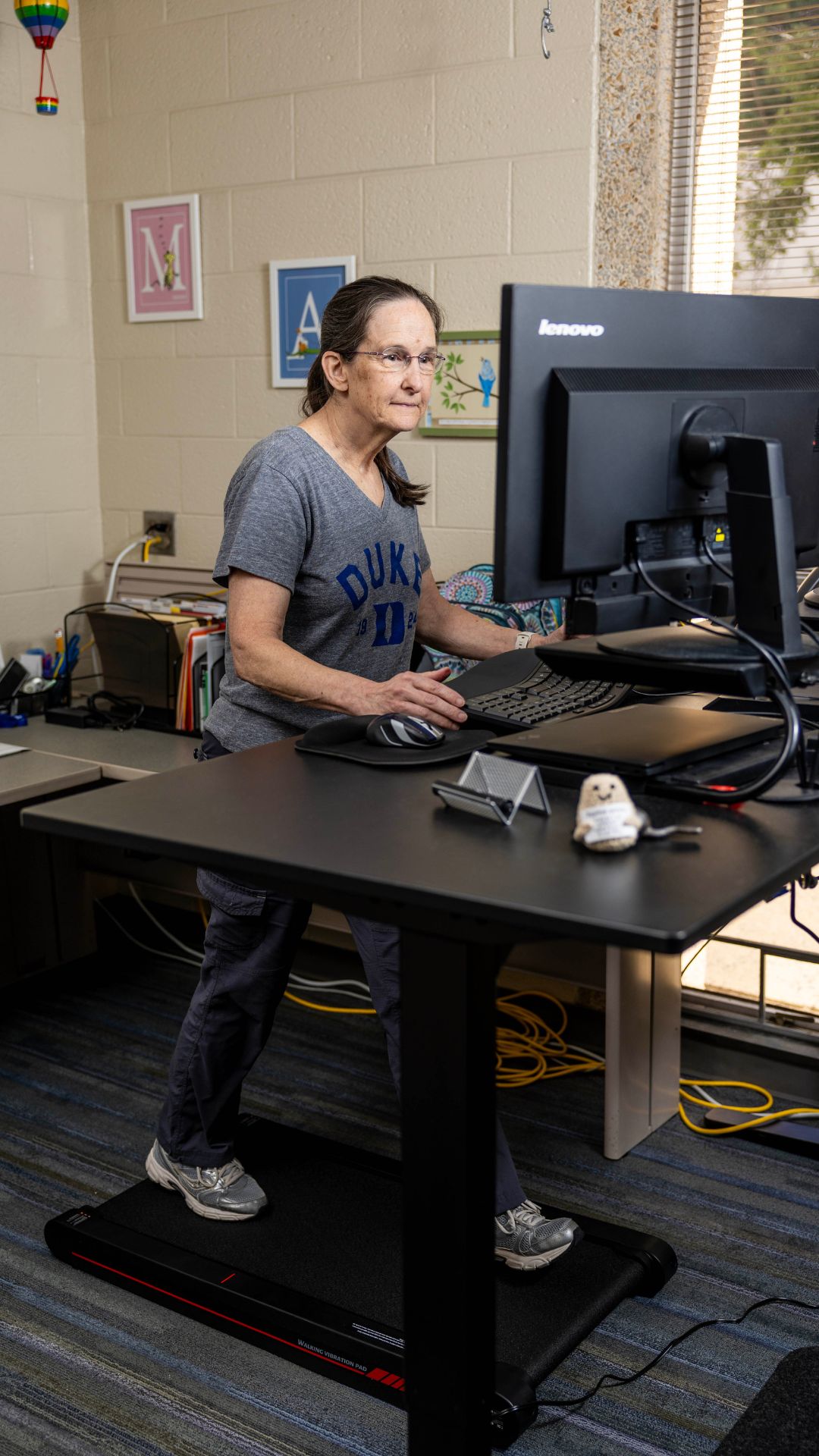 A woman walks on a walking pad in an office