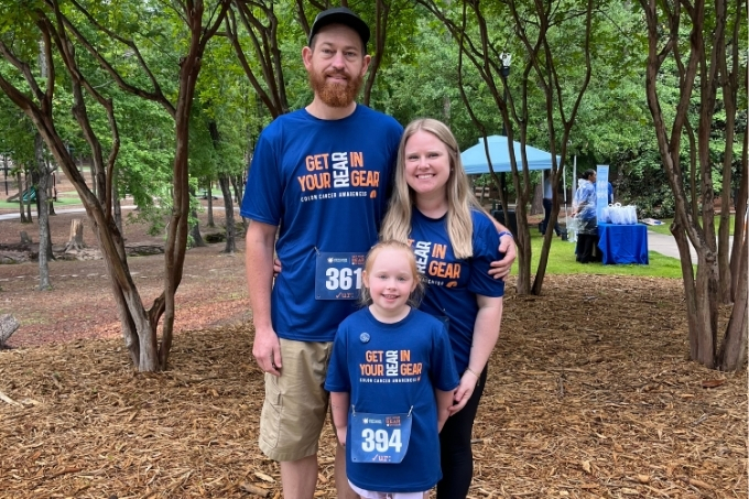 Laird family in a park wearing blue T-shirts that read 