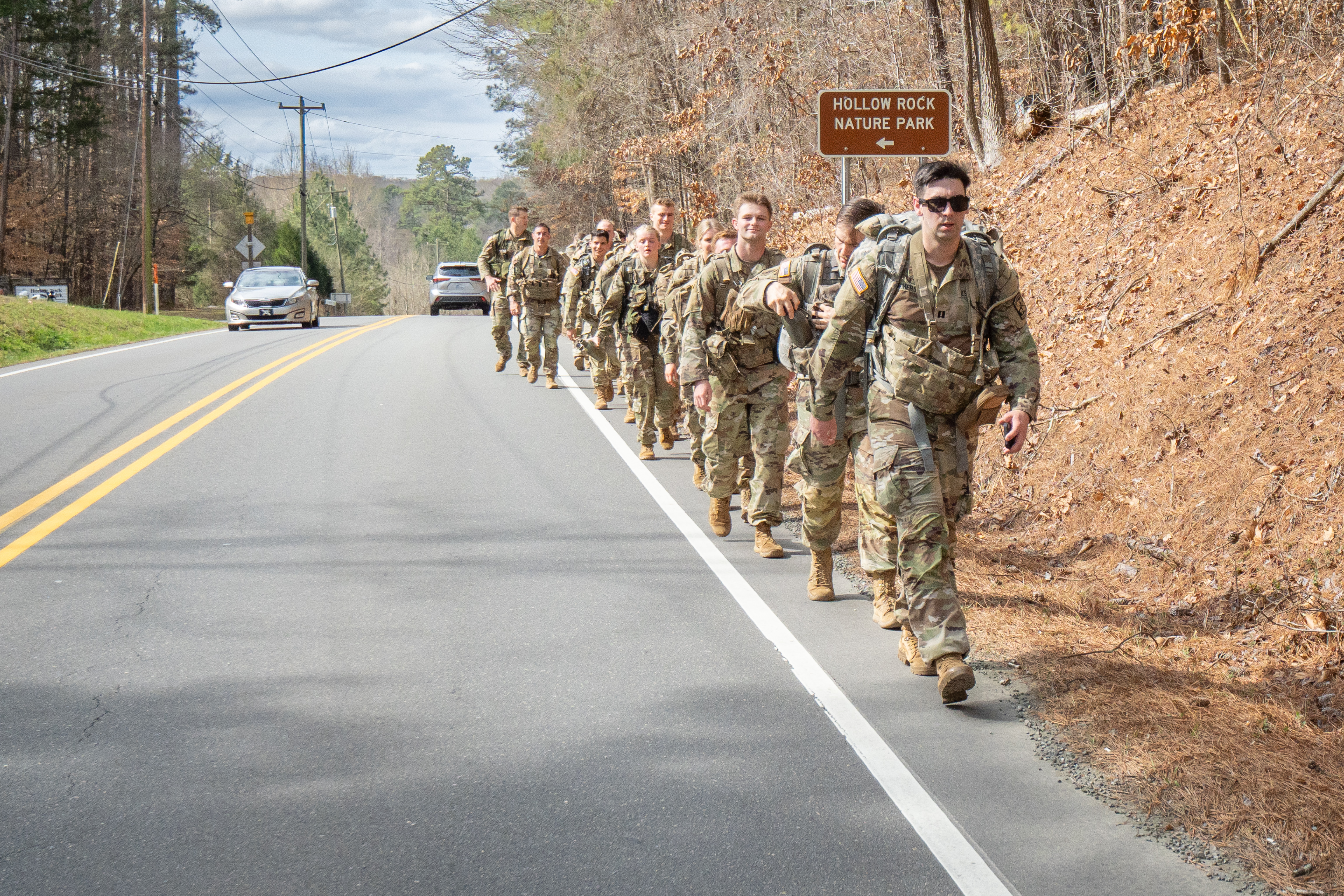 The group continues their walk past a "Hollow Rock Nature Park" sign