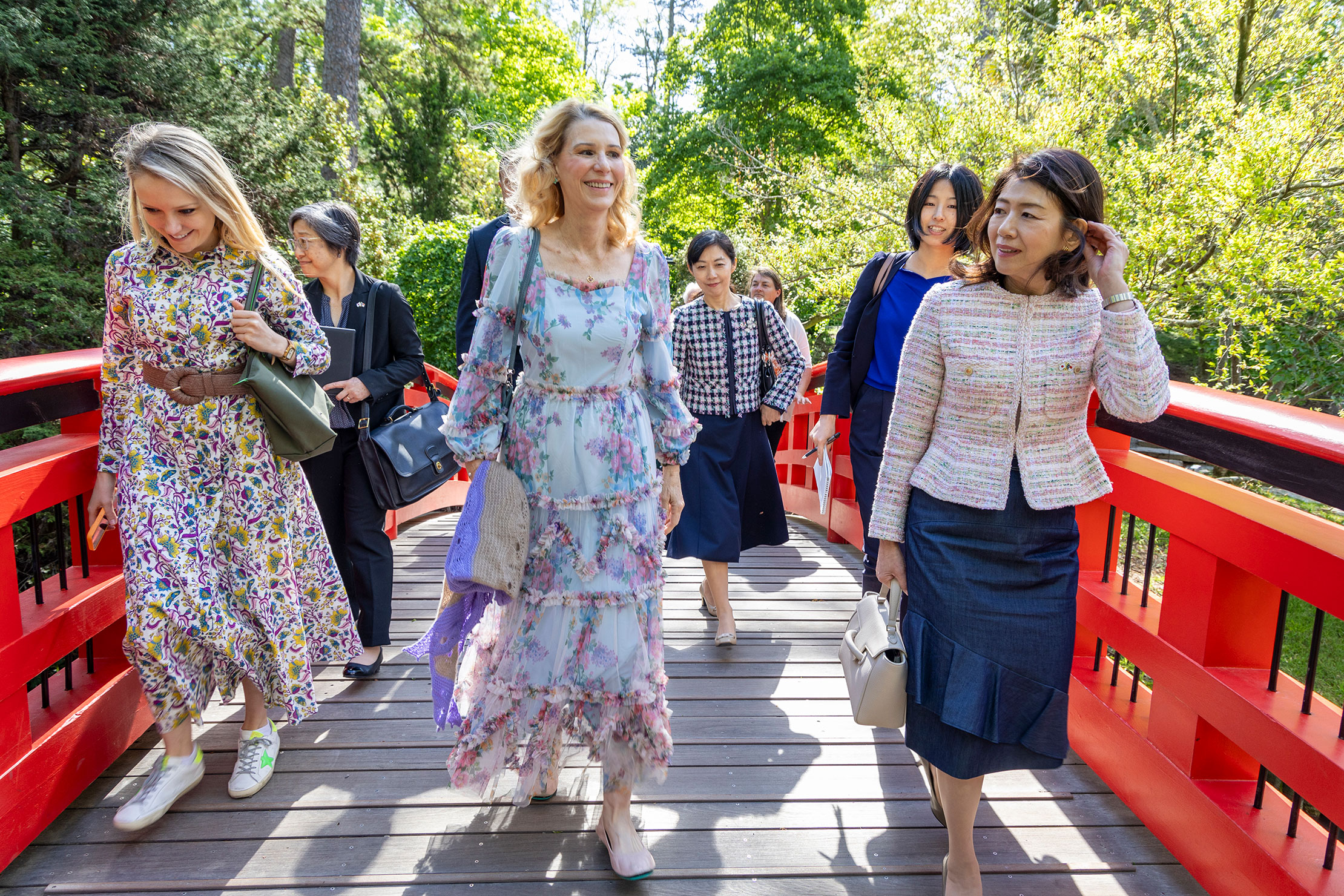 Kristin Cooper, first lady of North Carolina; center, Mio (Yamamoto) Maeda, spouse of consul general of Japan in Atlanta; background center, and Yuko Kishida, spouse of the prime minister of Japan, walk across the Meyer Bridge.
