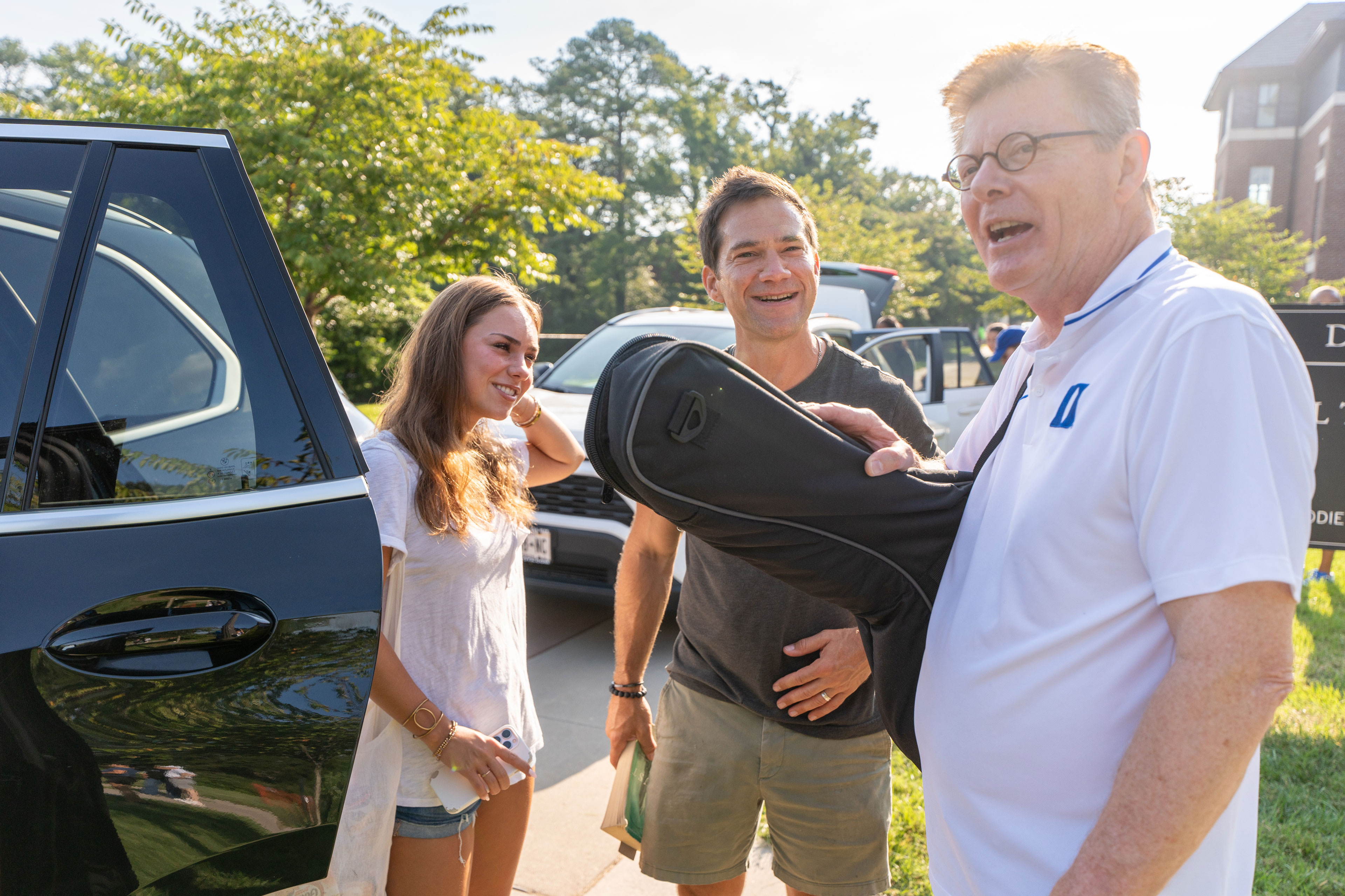 President Price grabs a guitar as he greets families and helps unloads cars.