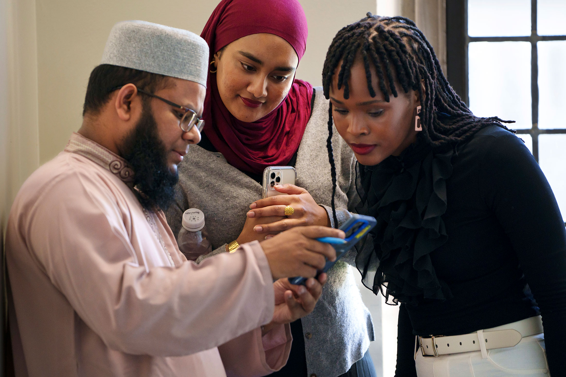 Muhammad Mohsin from the University of Dhaka, Bangladesh shows fellows Tamina Rauf and Andile Mnguni his phone.
