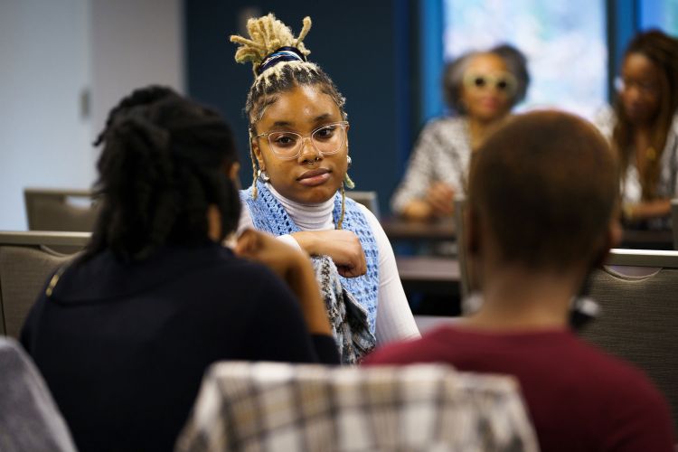 Students discuss with each other with speakers sitting in the background