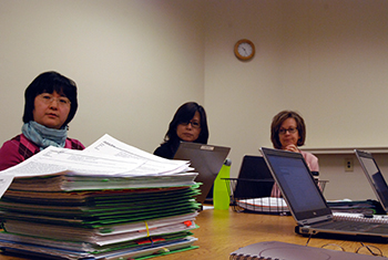 A large stack of grant proposals and requests meets members of the Office of Research Support each week. Staff typically see an increase in workload during summers as faculty submit their proposals. Photo by Bryan Roth.