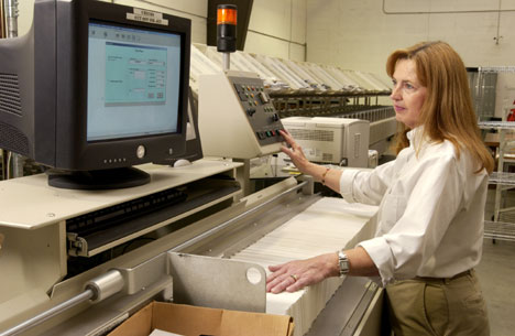 Carol Hawkins sorts envelopes in the Duke post office. 