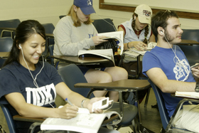 Students in a Spanish class perform listening exercises with digital audio players. 