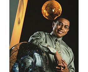 Professor Arlie Petters poses with a model of the solar system 
