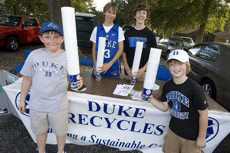 Ramsey and Logan Elliott and Jake and Keir Schwarze collect plastic cups at a Duke home football game. 