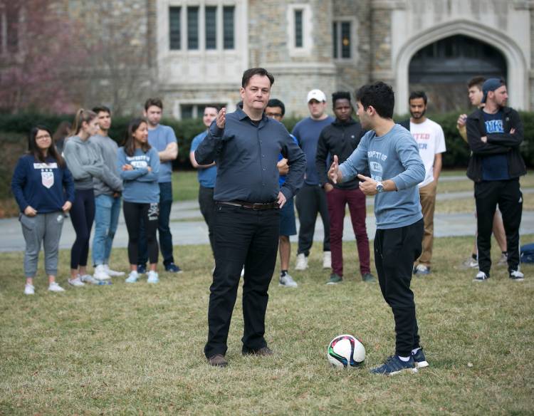 El profesor Laurent Dubois saca de la sala de clases a sus alumnos para aprender algunas técnicas de fútbol en el patio de la universidad.