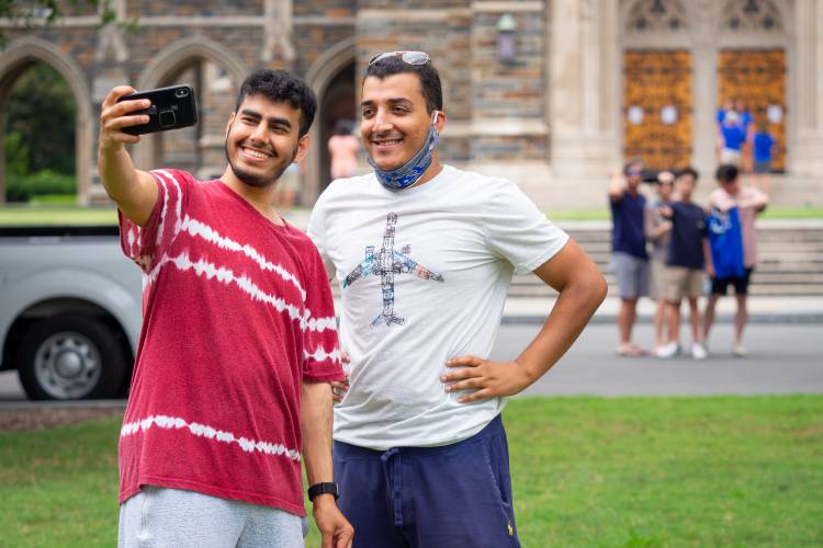 Incoming freshman and their families take selfies on Chapel quad on the first day of move-in for the class of 2024.