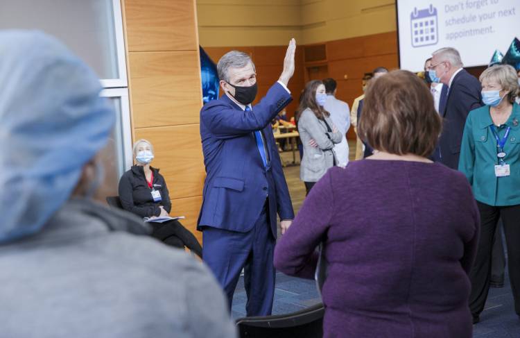 Governor Cooper gesturing while speaking with people inside the hospital
