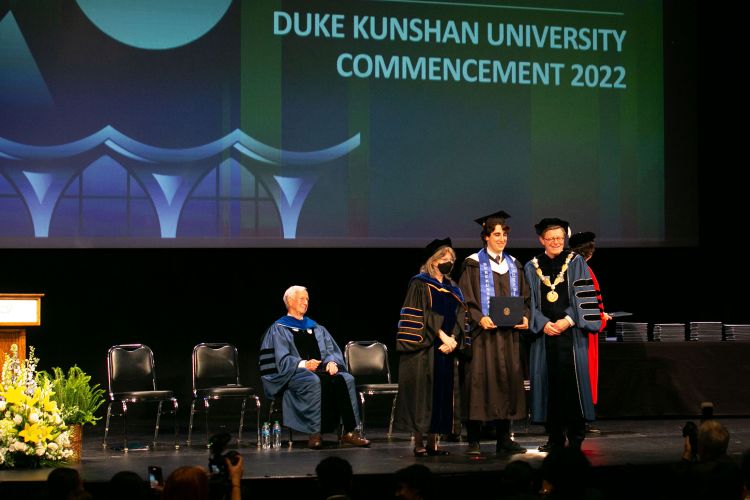 President Vincent Price and Provost Sally Kornbluth present degrees to the DKU students graduating in Durham. President Emeritus Richard Brodhead looks on.