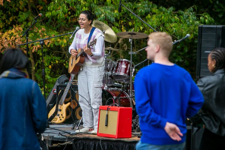 Senior Ila Amiri performs for classmates as part of the Democracy Day festivities in the parking lot across the street from the Karsh Alumni and Visitors Center