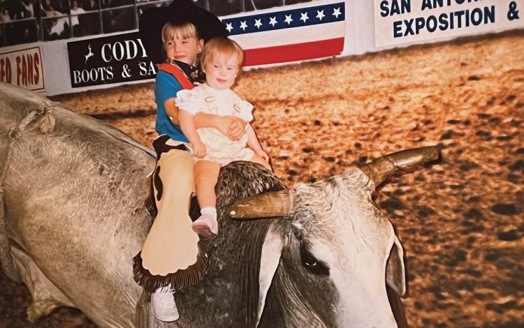Growing up outside of Houston, Amanda Hargrove, shown here posing with her younger sister on a stuffed bull, was able to enjoy plenty of quintessentially Texan experiences as a kid. Photo courtesy of Amanda Hargrove.