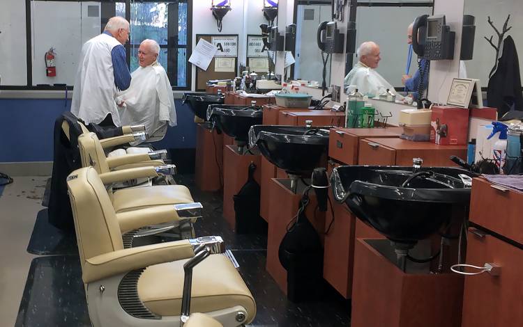 Dave Fowler cuts the hair of longtime customer Bill Racine.