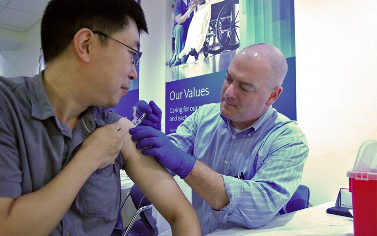 Changzheng Du receives his flu shot during a recent flu blitz event. Photo by Stephen Schramm.