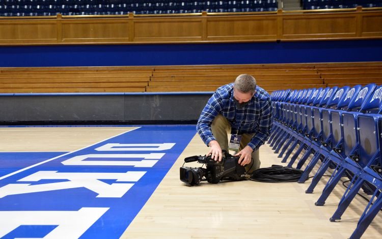 The Blue Devil Network's Chad Lampman checks a camera during the pre-game quiet. Photo by Stephen Schramm.