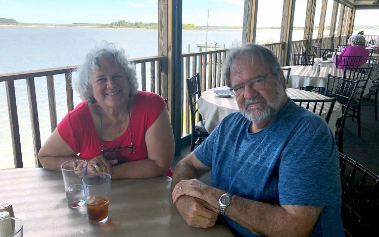 Diana Silimperi, left, and her husband Jos Muffels enjoy an outdoor lunch in Pamlico County last summer. Photo courtesy of Diana Silimperi.